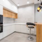 Spacious modern kitchen with minimalist design, featuring wooden accents and sleek appliances.