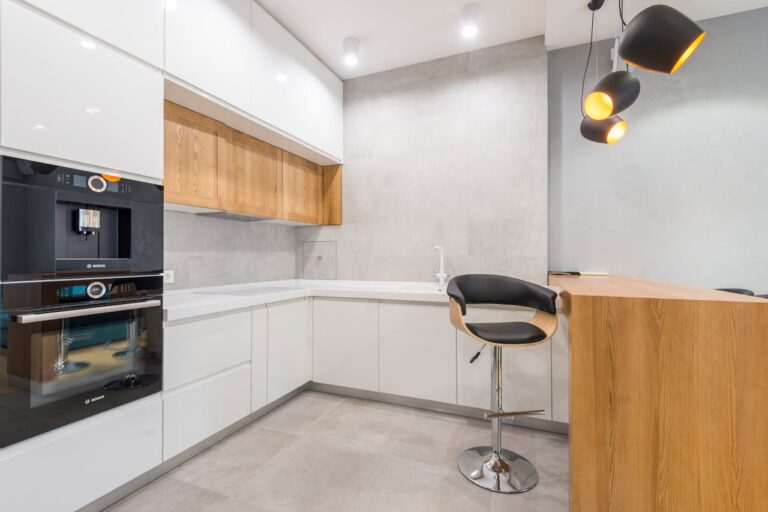 Spacious modern kitchen with minimalist design, featuring wooden accents and sleek appliances.