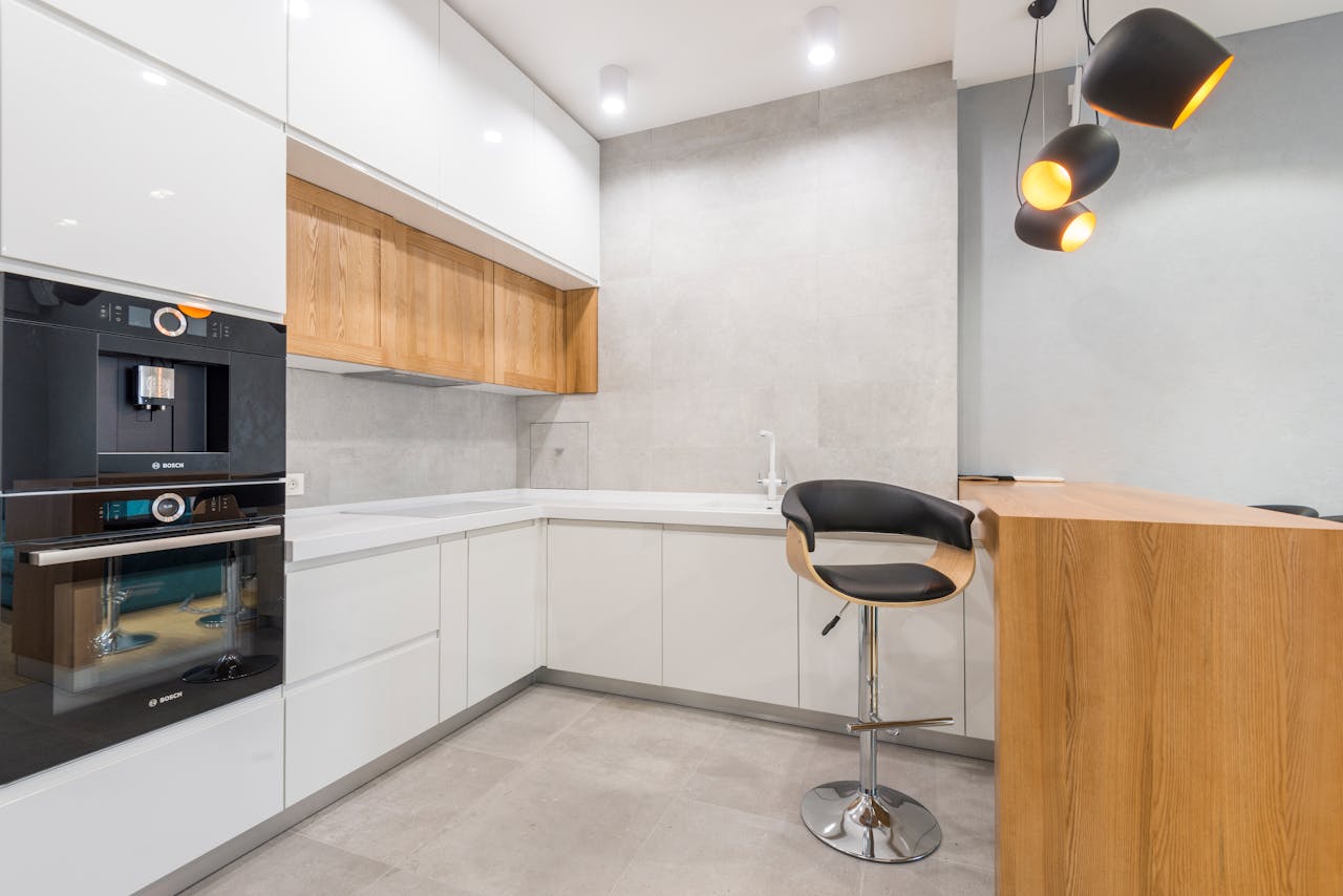 Spacious modern kitchen with minimalist design, featuring wooden accents and sleek appliances.